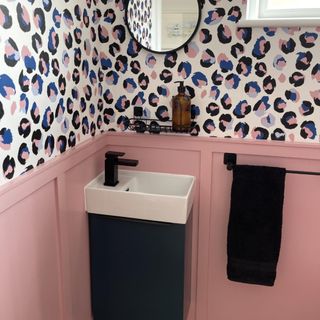 downstairs loo with sink and black tap and animal print wallpaper