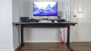 The Herman Miller Coyl Gaming Desk set up in a corner with a PC, monitor and other accessories on top