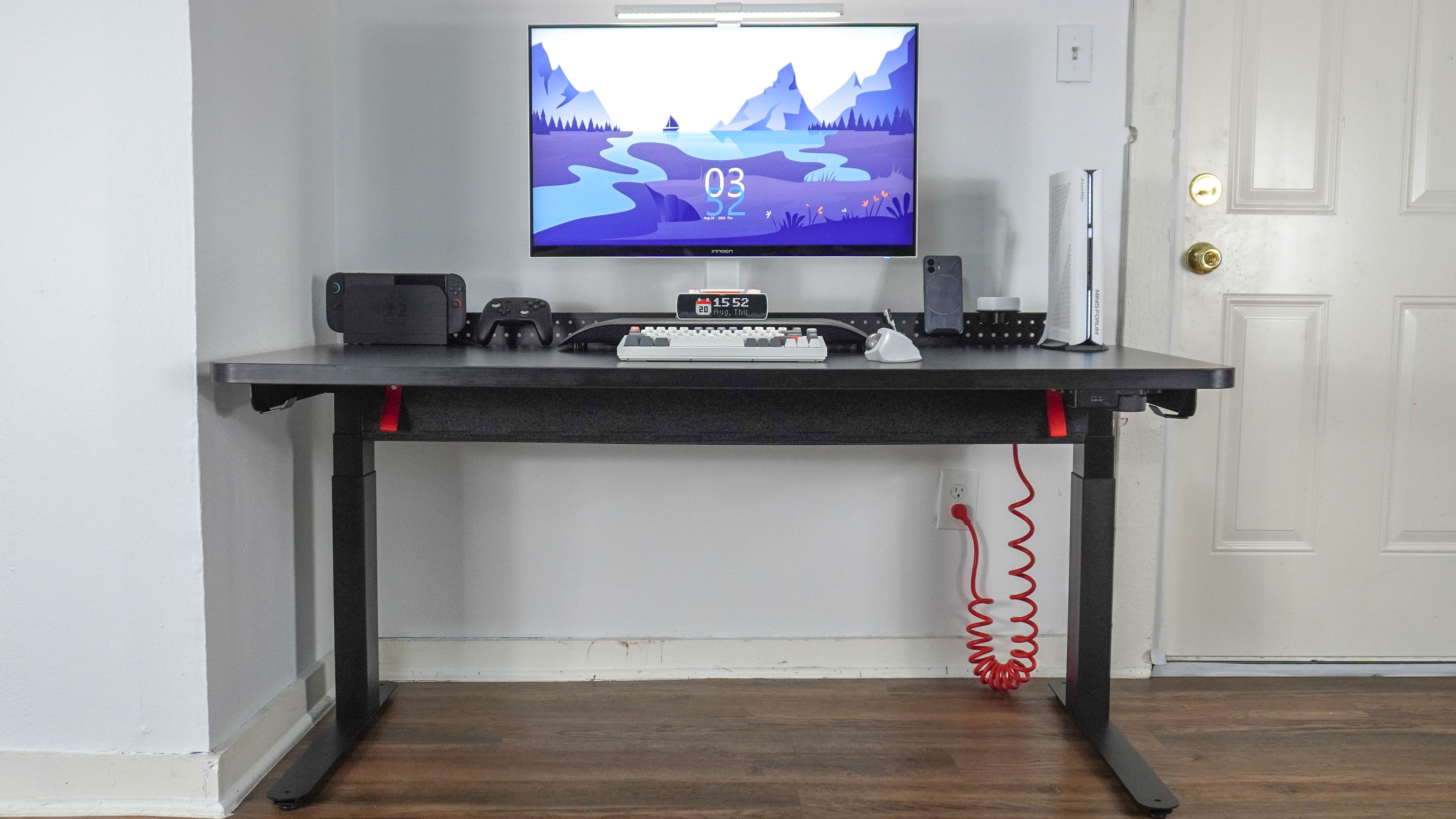 The Herman Miller Coyl Gaming Desk set up in a corner with a PC, monitor and other accessories on top