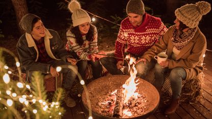 family toasting marshmallows over a fire pit