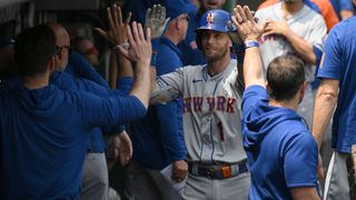 Jeff McNeil is congratulated in the Mets dugout after hitting a home run