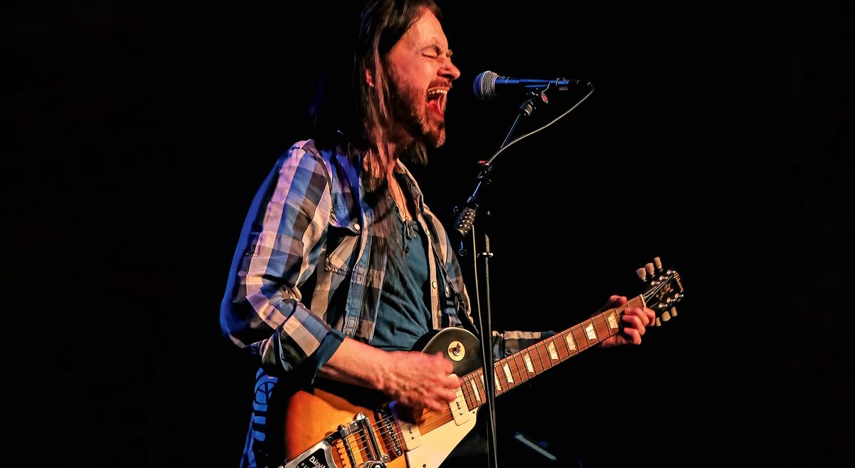 Steve Logan plays his Bigsby-equipped Gibson Les Paul Standard on stage and screams into the mic.