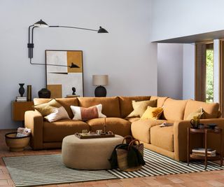 modern white living room with orange sofa and black wall light