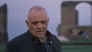 Anthony Hopkins standing in front of Roman ruins.