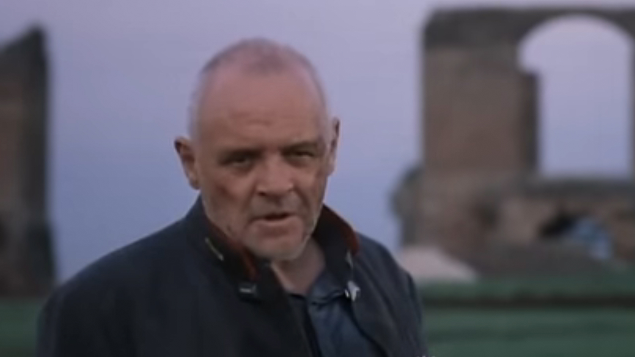 Anthony Hopkins standing in front of Roman ruins.