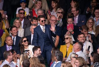 Tom Cruise (centre) waves to the fans at Wimbledon