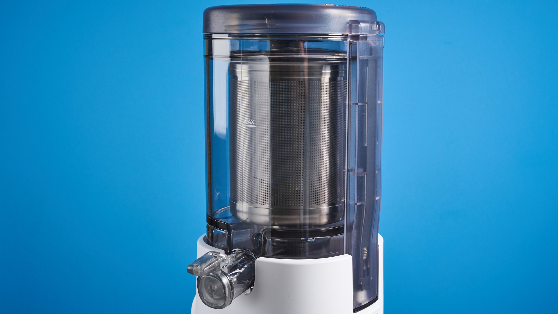 the nama m1 plant-based milk maker in white with a pitcher, blade frame, and strainer, and a pulp mat accessory with a brush