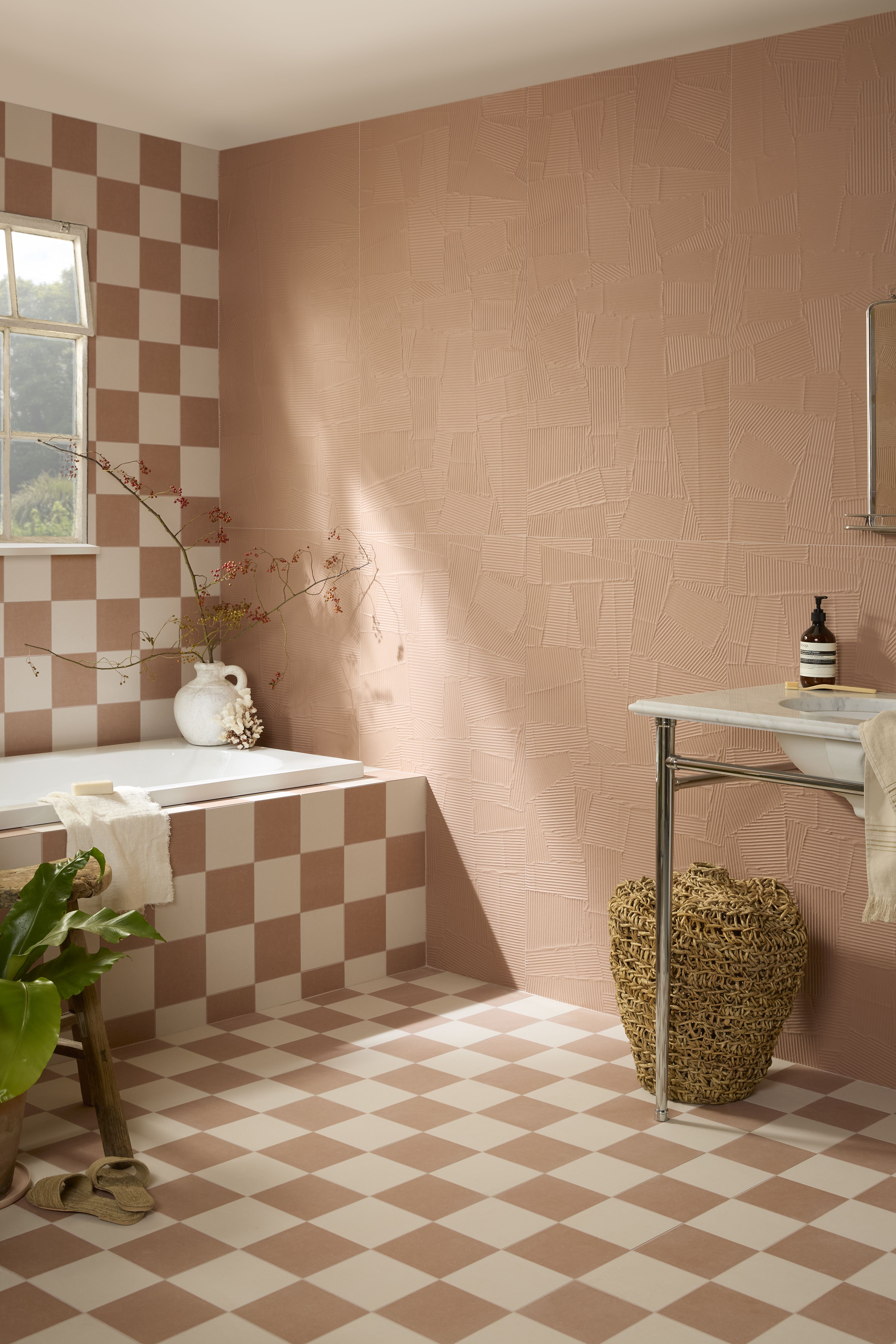 Image of a bathroom with pink plaster tile walls and pink and white checkerboard flooring 