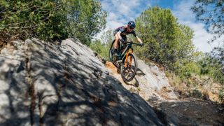 The new Wilier Urta Max SLR cross-country mountain bike being ridden down a rock slab