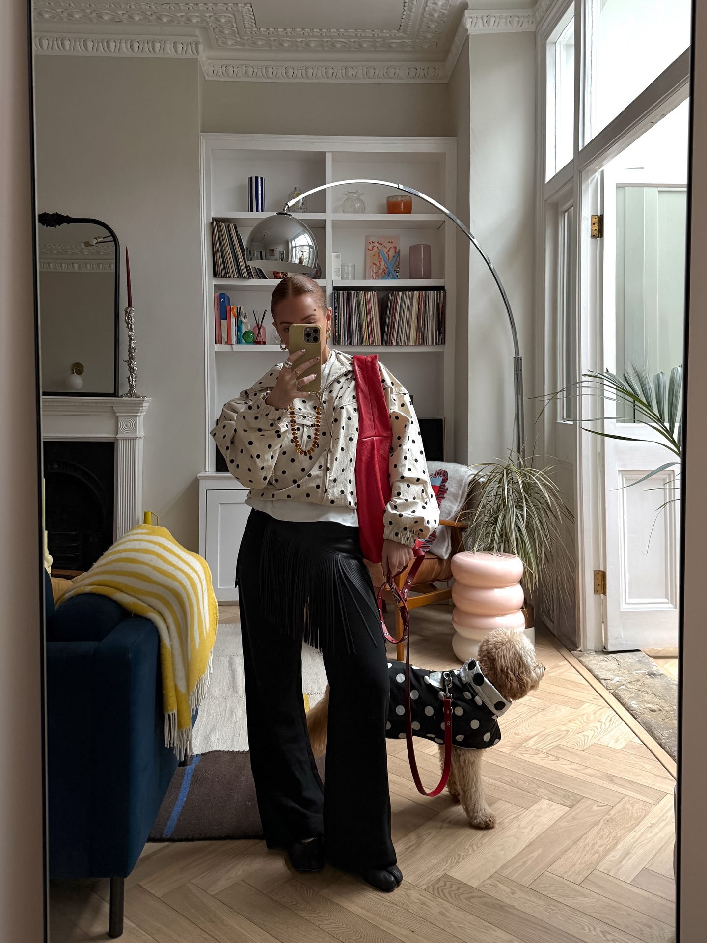 Rebecca Ferrazwyatt wears a polka dot jacket, black trousers and a red shoulder bag