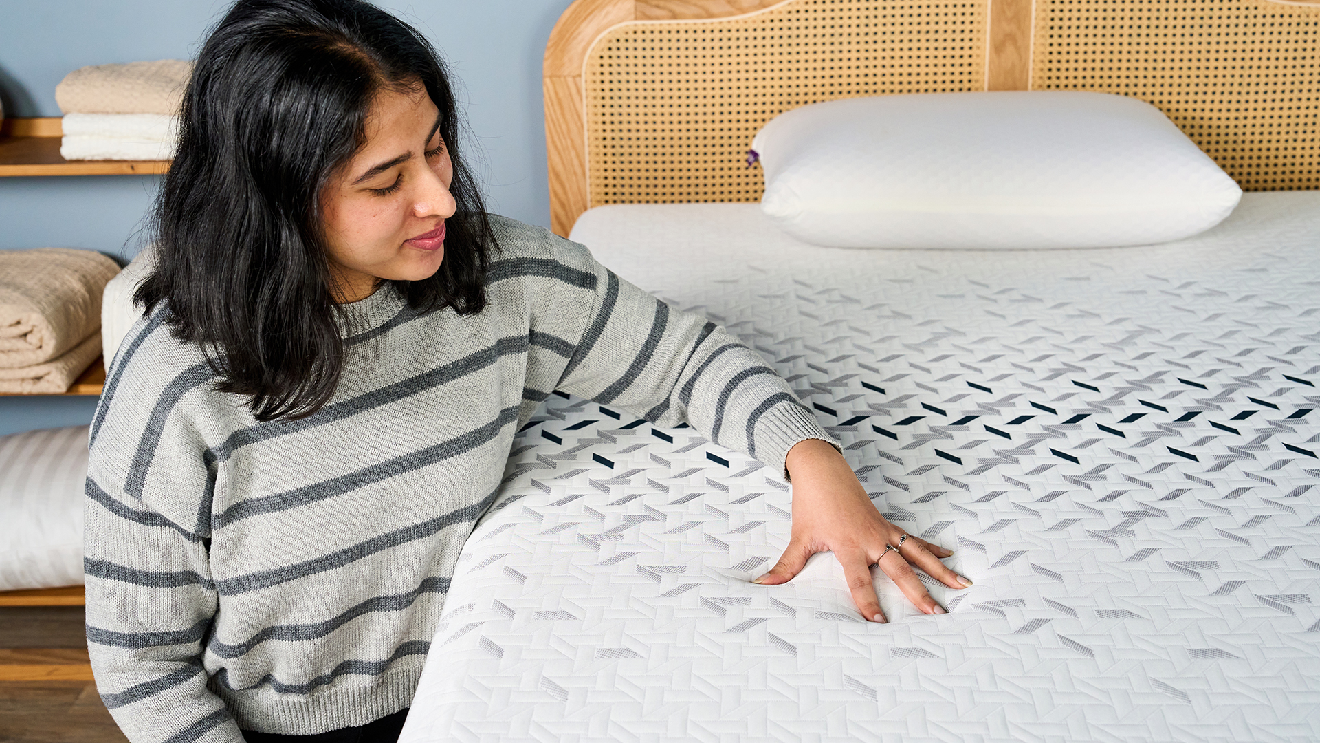 A female Tom's Guide mattress tester resting her hand on the soft, cooling cover of the Nectar Ultra Hybrid mattress