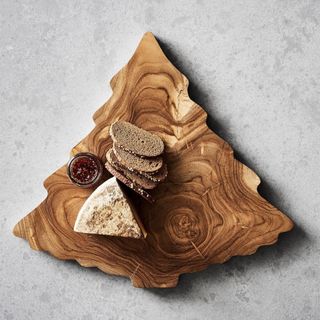 Teak Wood Tree Cheese Board against a gray background. 