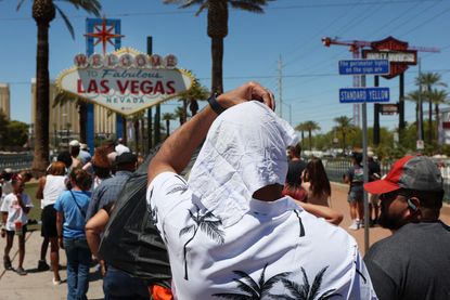 A man shields himself from the sun in Las Vegas during a heat wave.