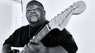 A photo of Christone "Kingfish" Ingram posing with his signature Fender Telecaster Custom