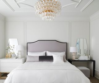 hotel style white bedroom with a paneled ceiling and lilac headboard