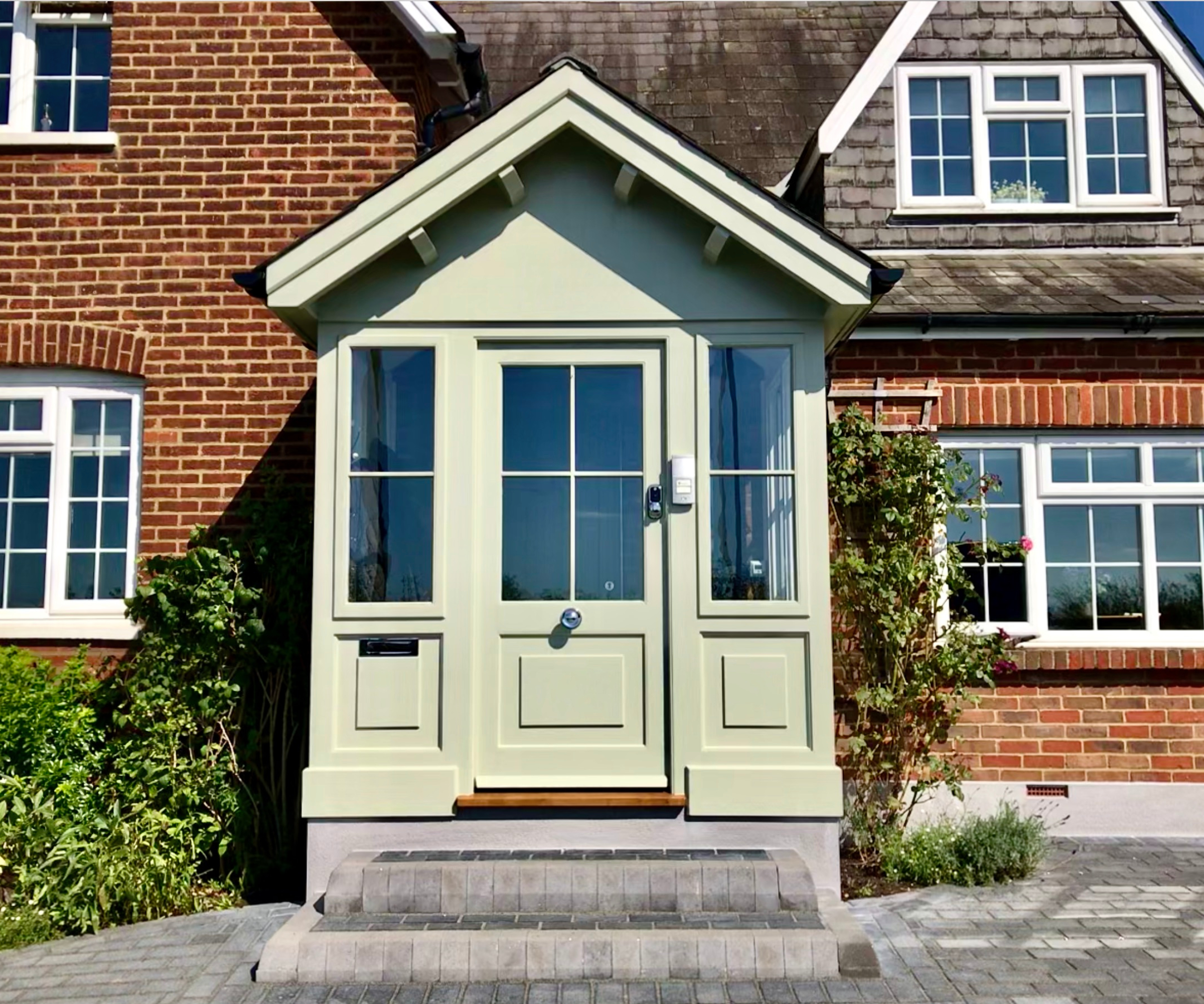 pale green fully enclosed porch kit with glazed windows, half glazed door and pitched roof