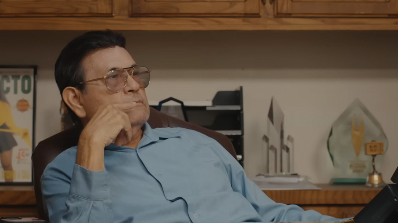 A screenshot of a man at a desk in Selena y Los Dinos: A Family's Legacy