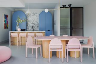 a kitchen with blue arched cabinets and pink furniture