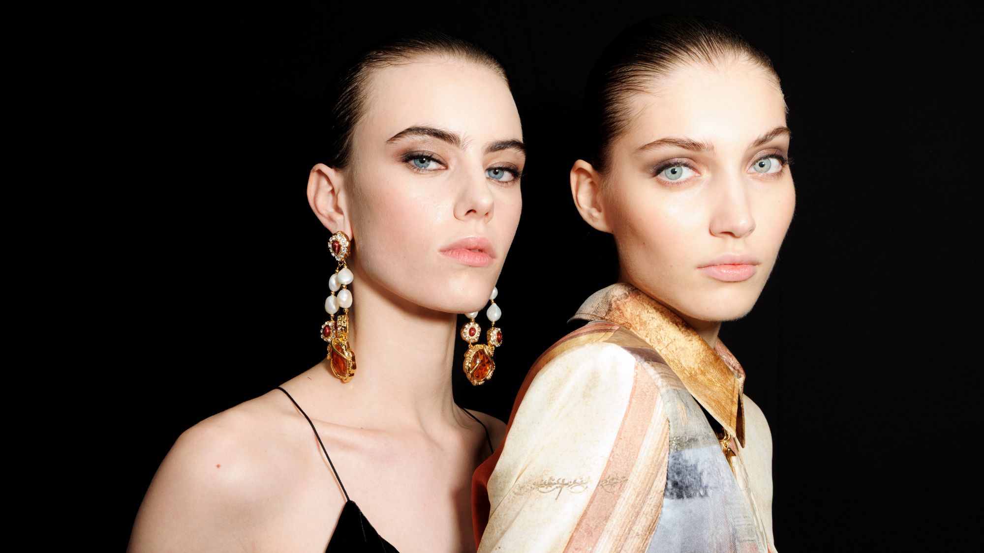 two models wearing smokey eyeshadow backstage at fashion week