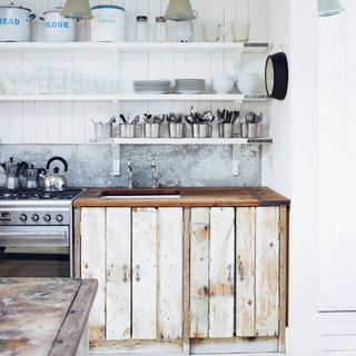 wood panelled cabin kitchen made from upcycled wooden planks and metal splashback