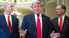 US President Donald Trump (C), alongside Senator Rick Scott (L), Republican from Florida, and Senator John Barrasso (R), Republican from Wyoming, speaks to the press after a lunch meeting with Senate Republicans at the US Capitol in Washington, DC, on June 24, 2026. President Trump said Wednesday he will refuse to sign a landmark housing bill, passed by Congress with broad bipartisan support, until lawmakers approve legislation that would overhaul American elections and restrict voter registration. (Photo by SAUL LOEB / AFP via Getty Images)