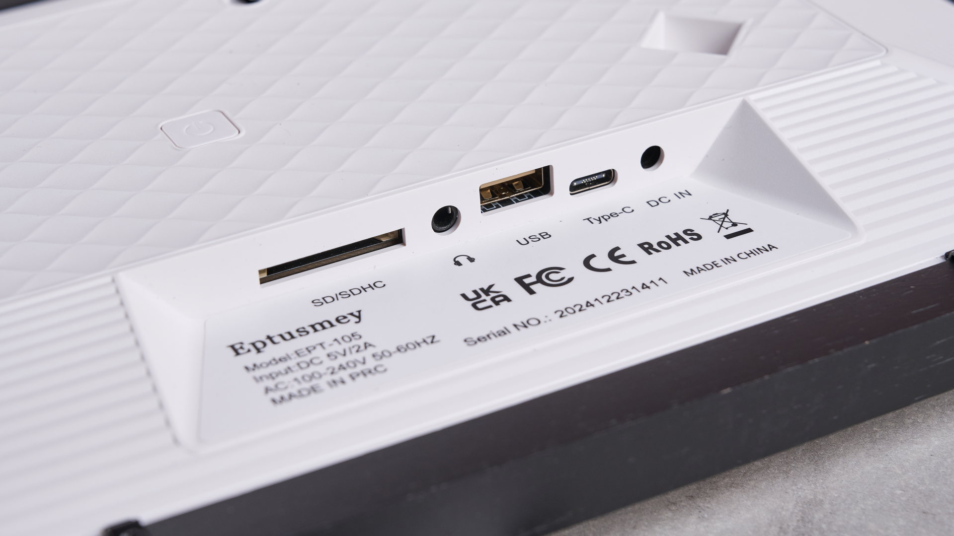 A closeup of the ports on the rear of the Eptusmey 10.1-inch WiFi Digital Photo Frame. It shows and SD card port, headphones jack, USB port, USB-C port and DC in.