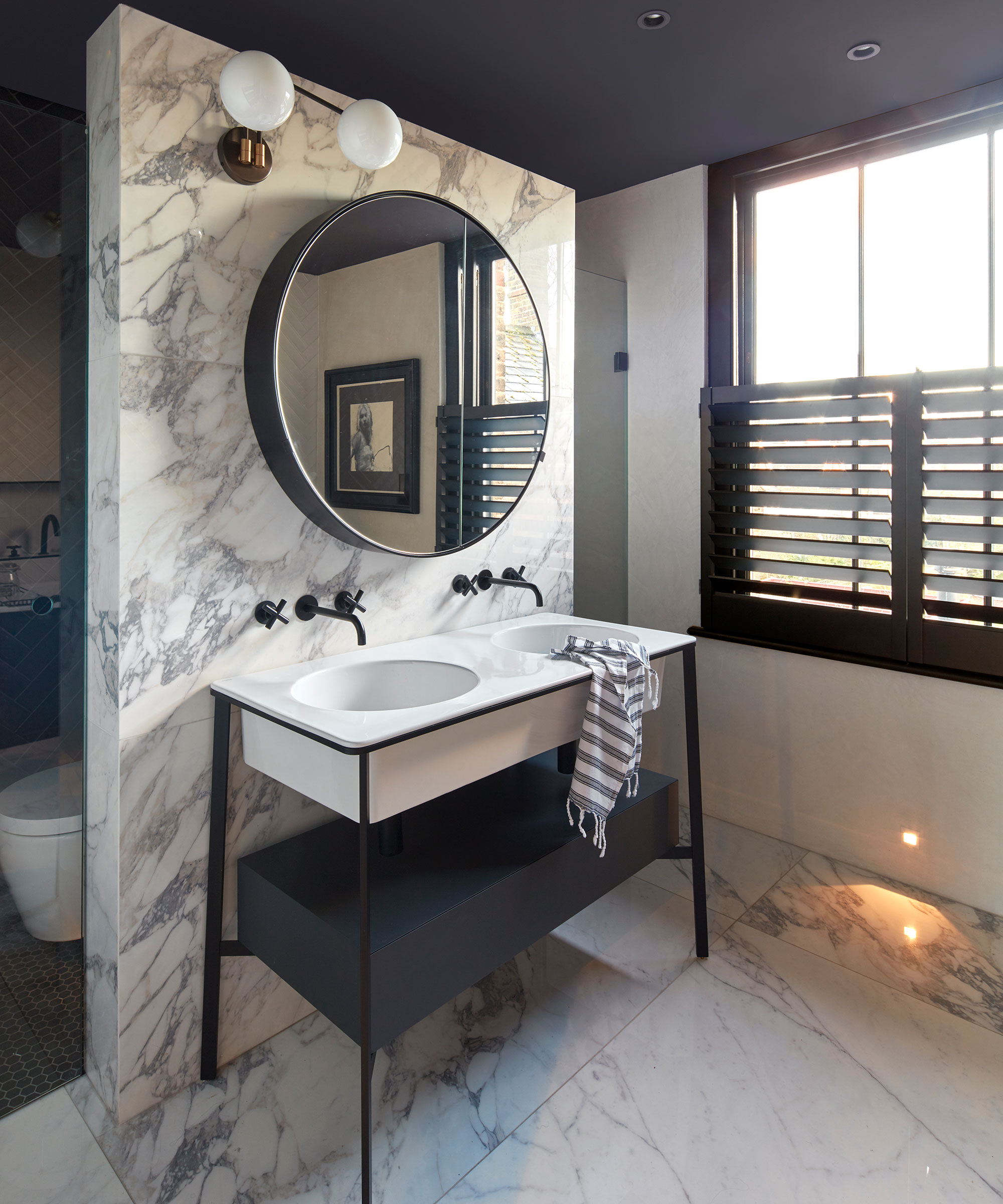 marble bathroom with twin basins and half window shutters