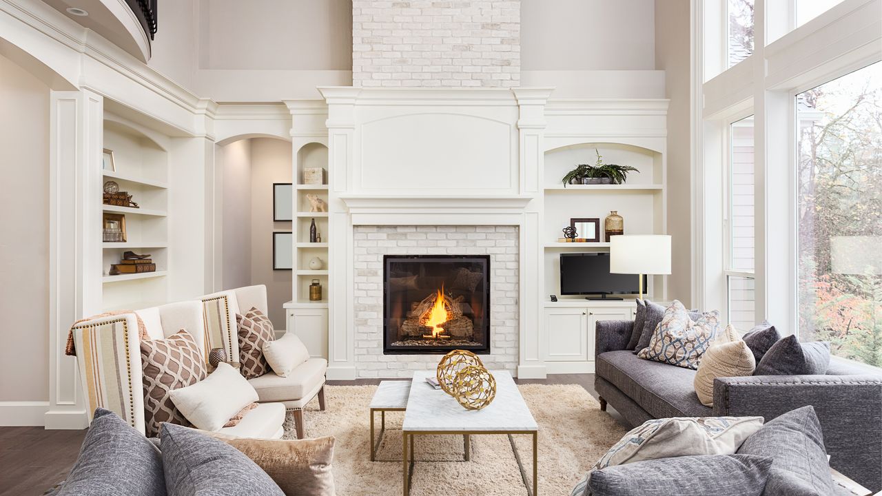 Beautiful living room interior with tall vaulted ceiling, loft area, hardwood floors and fireplace in new luxury home