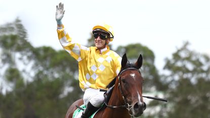 Jockey Blake Shinn waves to the crowd on Lady Of Camelot after a win