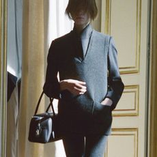 Two The Row models at the winter 2025 show carrying the new E/W India Bag.