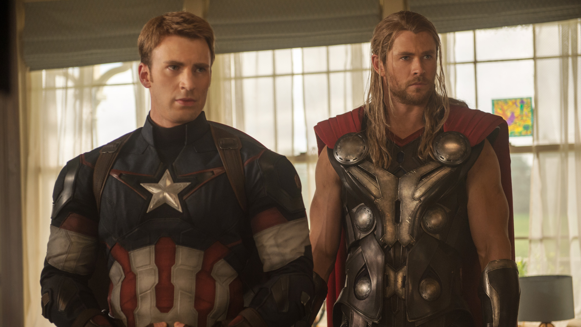 Steve Rogers (Chris Evans) and Thor (Chris Hemsworth) stand side by side in Avengers: Age of Ultron.