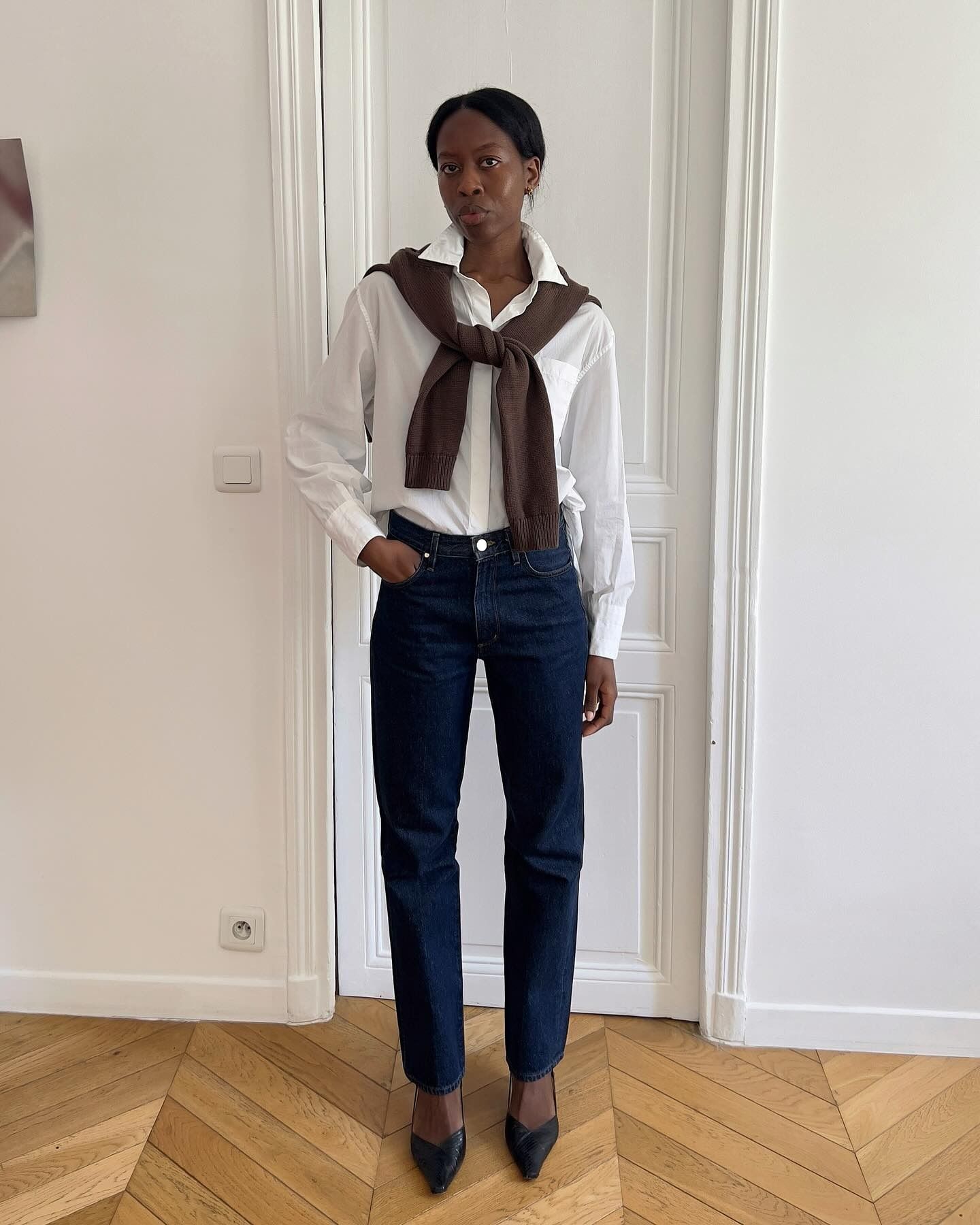 French influencer wearing a white button-down shirt with jeans