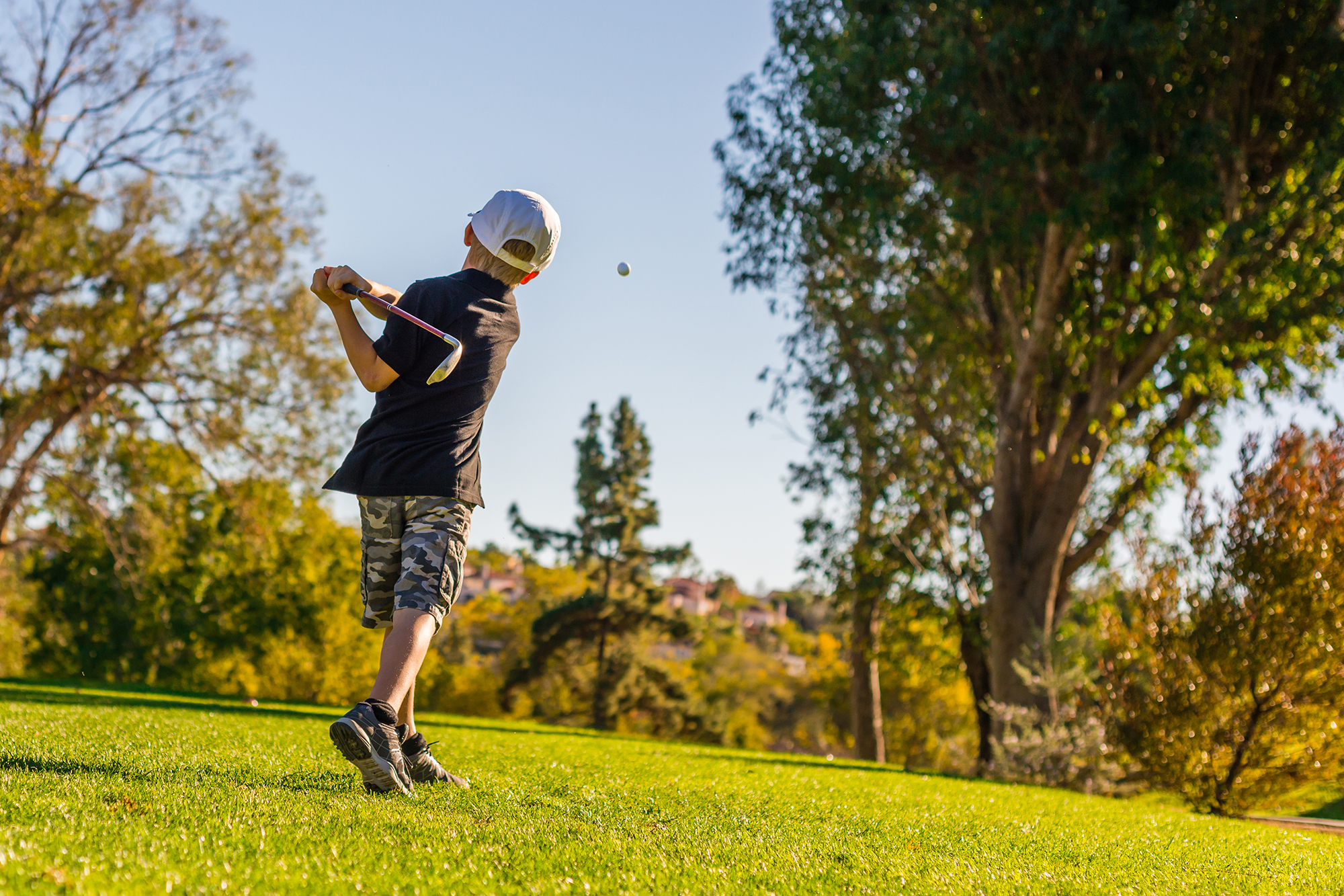 Junior golfer hitting the ball on a golf course