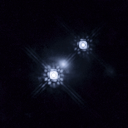 This Hubble picture shows a quasar that has been gravitationally lensed by a galaxy in the foreground, which can be seen as a faint shape around the two bright images of the quasar.