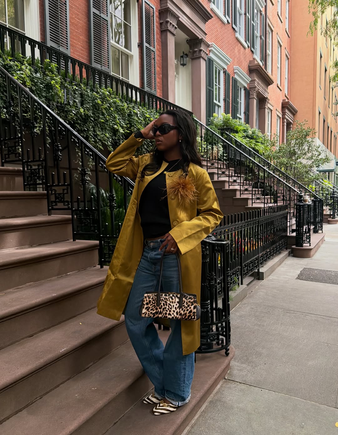 @devapollon wears a gold coat with blue jeans and animal print accessories