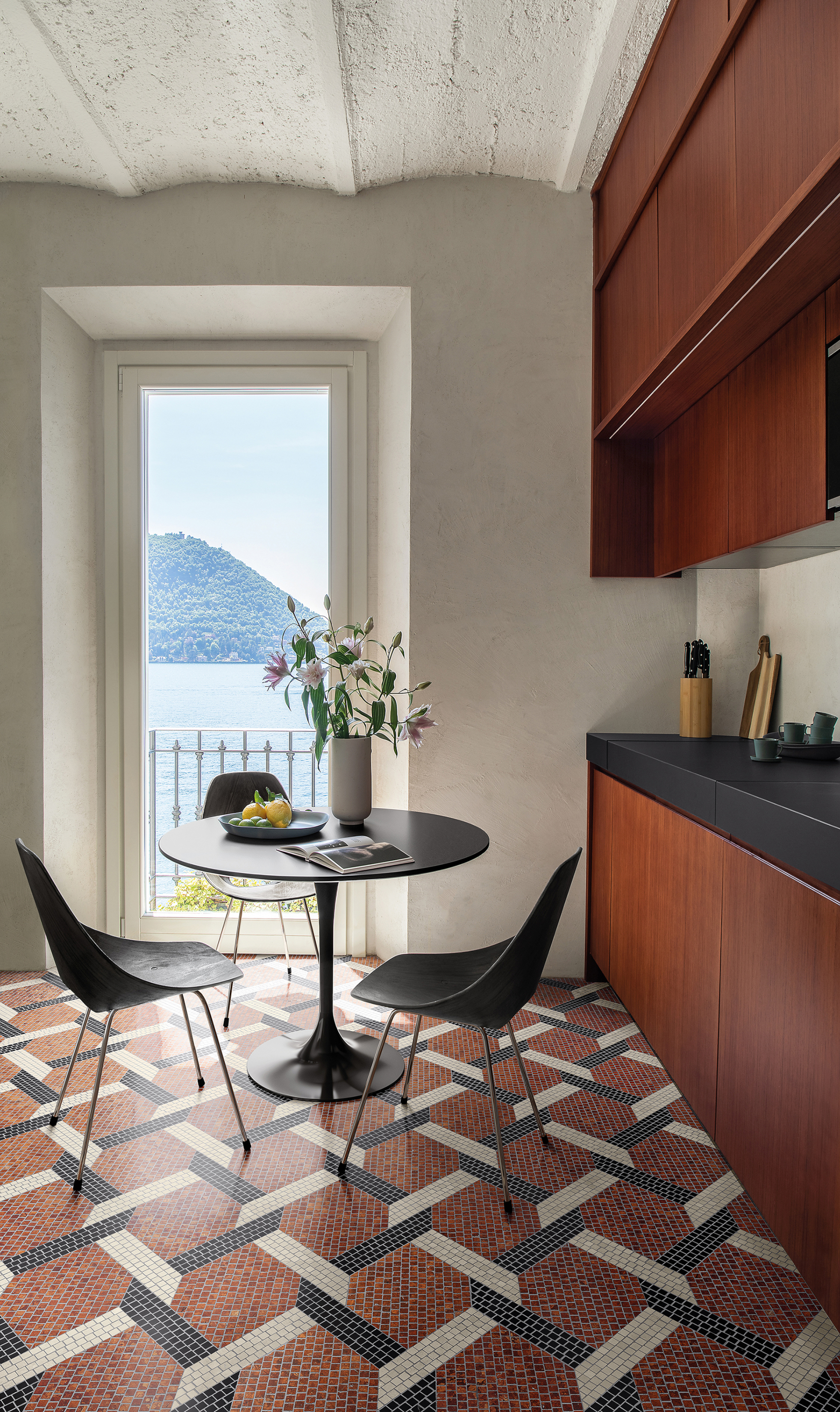 Dark wood kitchen with terracotta, white and black mosaic floor in geometric pattern