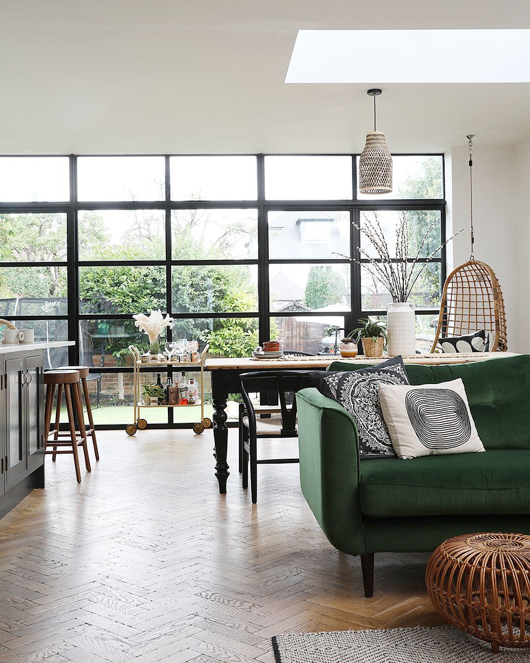 A kitchen extension with engineered parquet wood flooring and a contemporary Crittal style glass back looking out to the garden