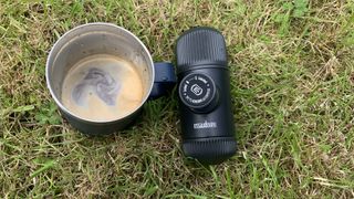The Nanopresso next to a cup of coffee