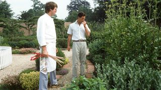 King Charles smells some herbs as he and his chef walk around his garden at Highgrove House