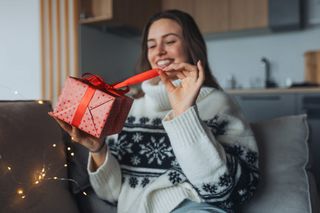 A happy woman opening a present.