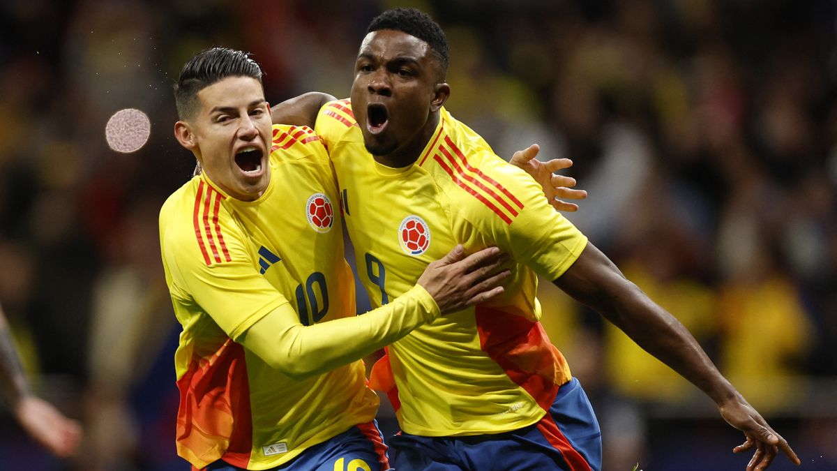 Jhon Cordoba (R) and James Rodriguez (L) celebrate a goal for Columbia in the country&#039;s yellow football shirt.