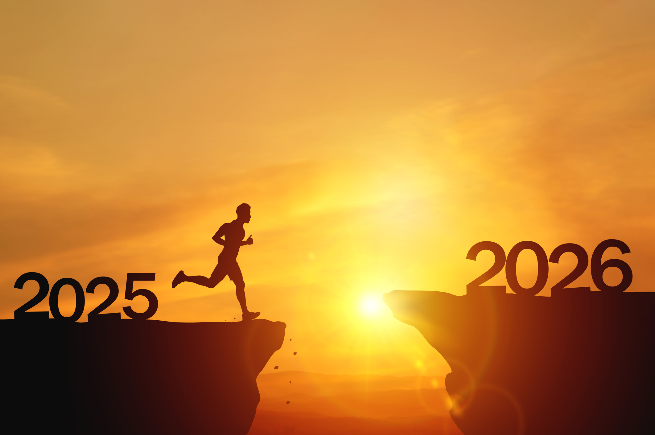 New Year 2026, Inspiration and progress towards new success. Silhouettes of human jumping over cliff towards finish line with text new year 2026 on sunset beautiful