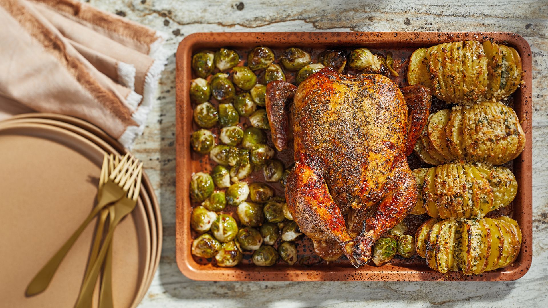 A roast chicken in a tray with sprouts and a chicken