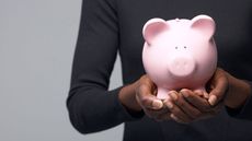 Woman carefully holding a piggy bank