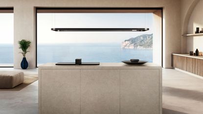 Modern kitchen with ocean views and a countertop with SMEG Pro Alta Isola hob and suspended light rail