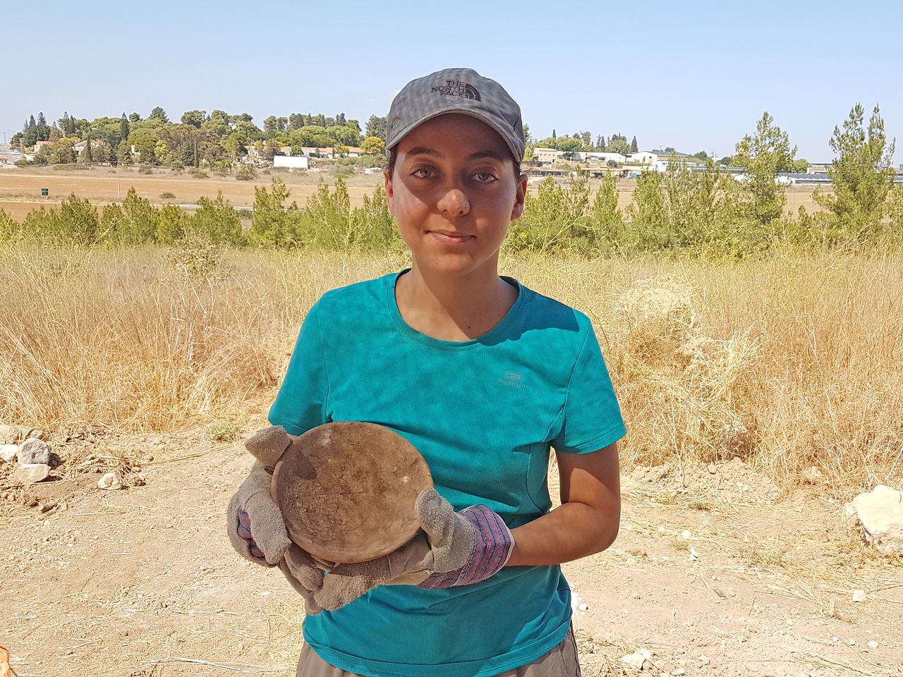 A youth holds a ceramic bowl unearthed at the fortress.
