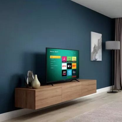 A flat screen television standing on a floating entertainment unit in a modern living room.