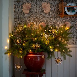 A Christmas foliage arrangement with DIY decorations made from tomato paste tube