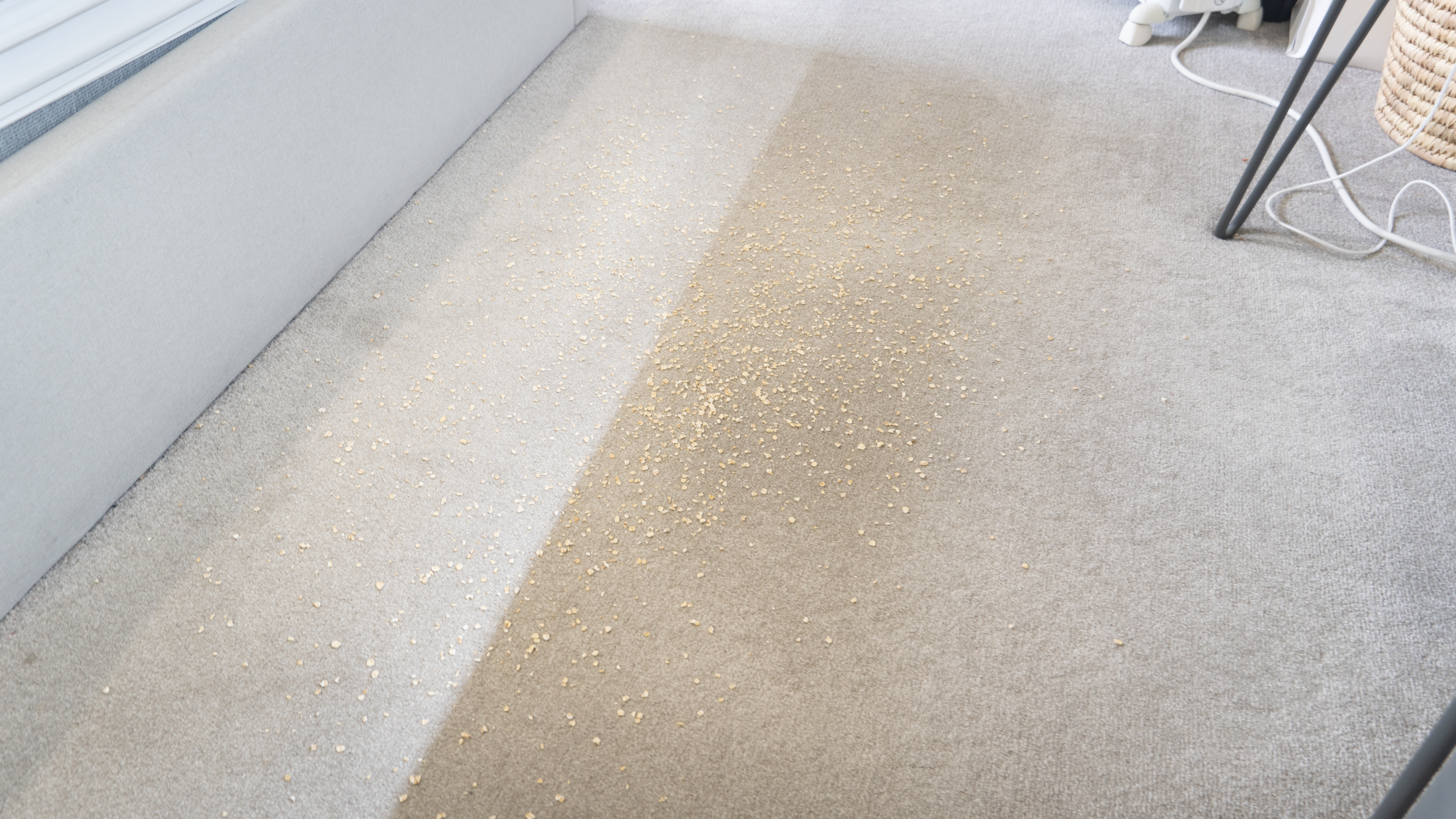 Oats sprinkled on carpet in front of Eufy E20, ready for suction test