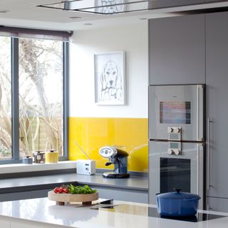 kitchen with worktop and yellow glass splashback